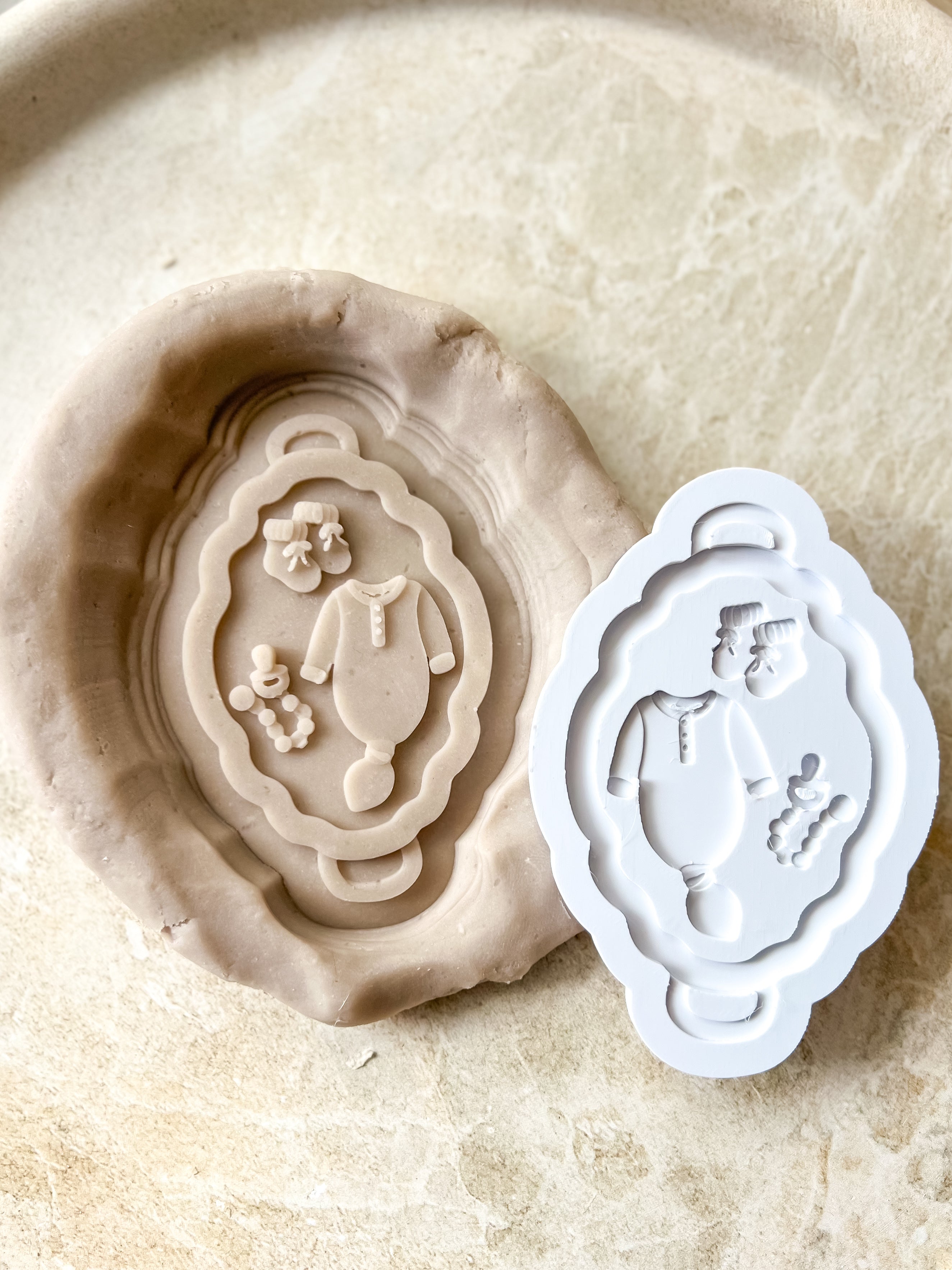Neutral baby items on flat bassinet debosser and cutter