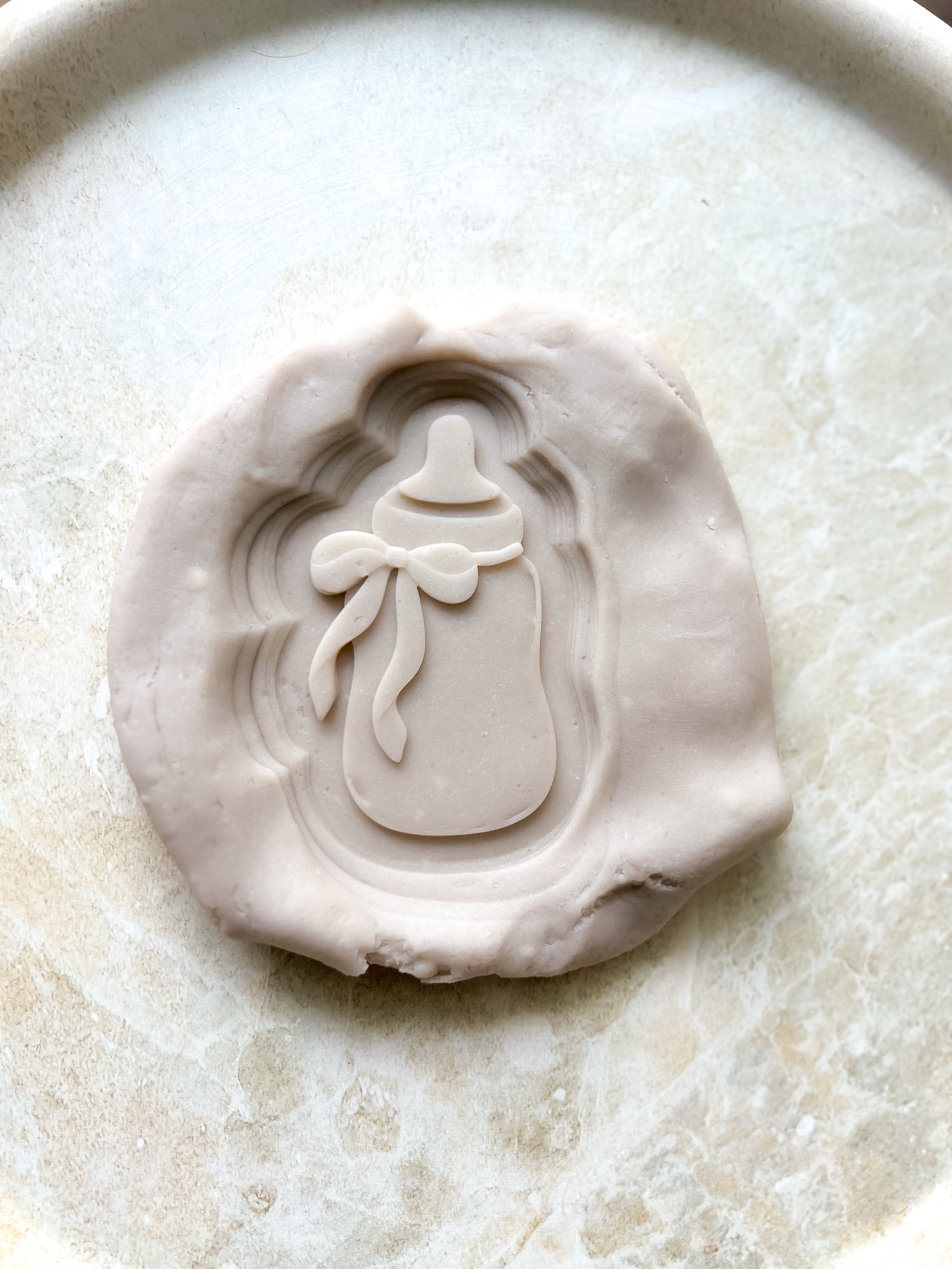 Baby bottle with bow debosser and cutter