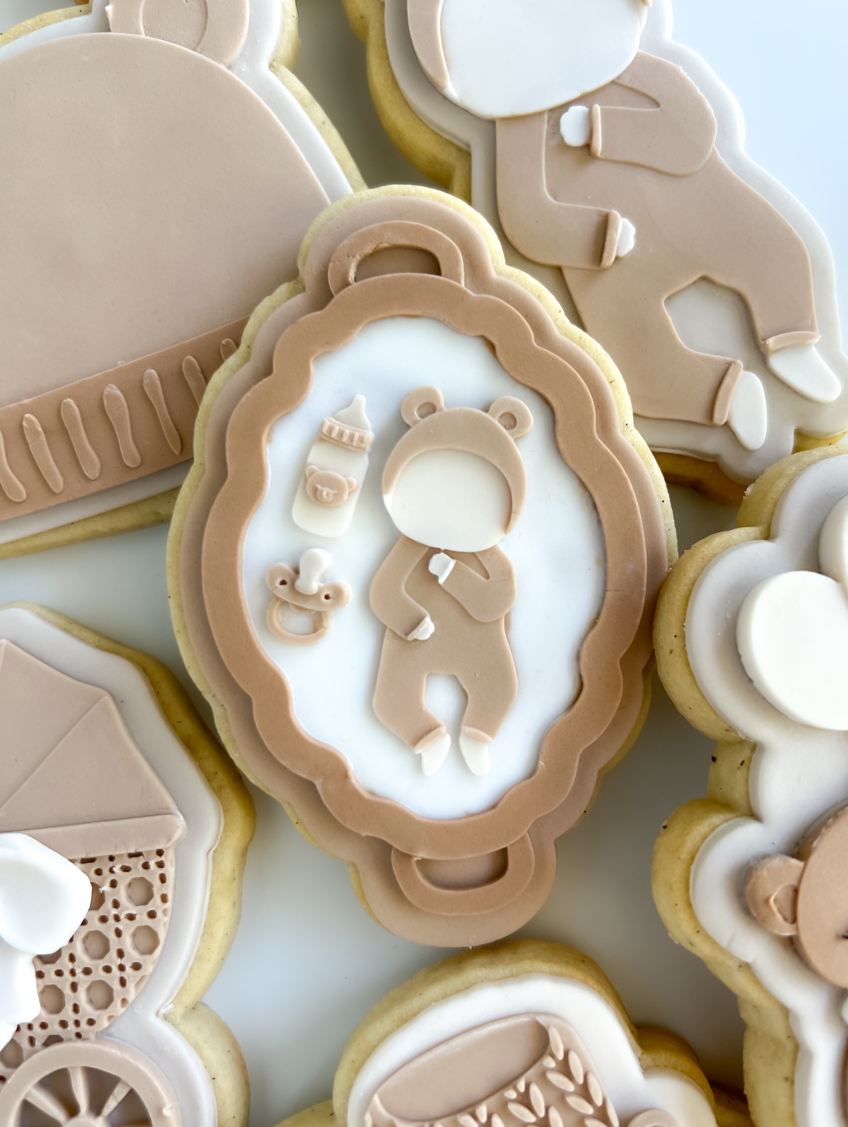 Baby in bear onesie on flat bassinet debosser and cutter