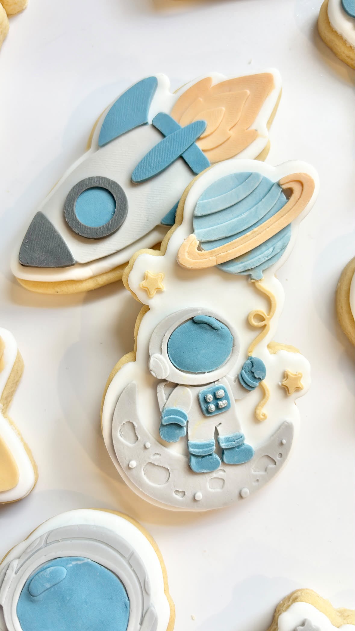 Astronaut holding Saturn balloon debosser and cutter