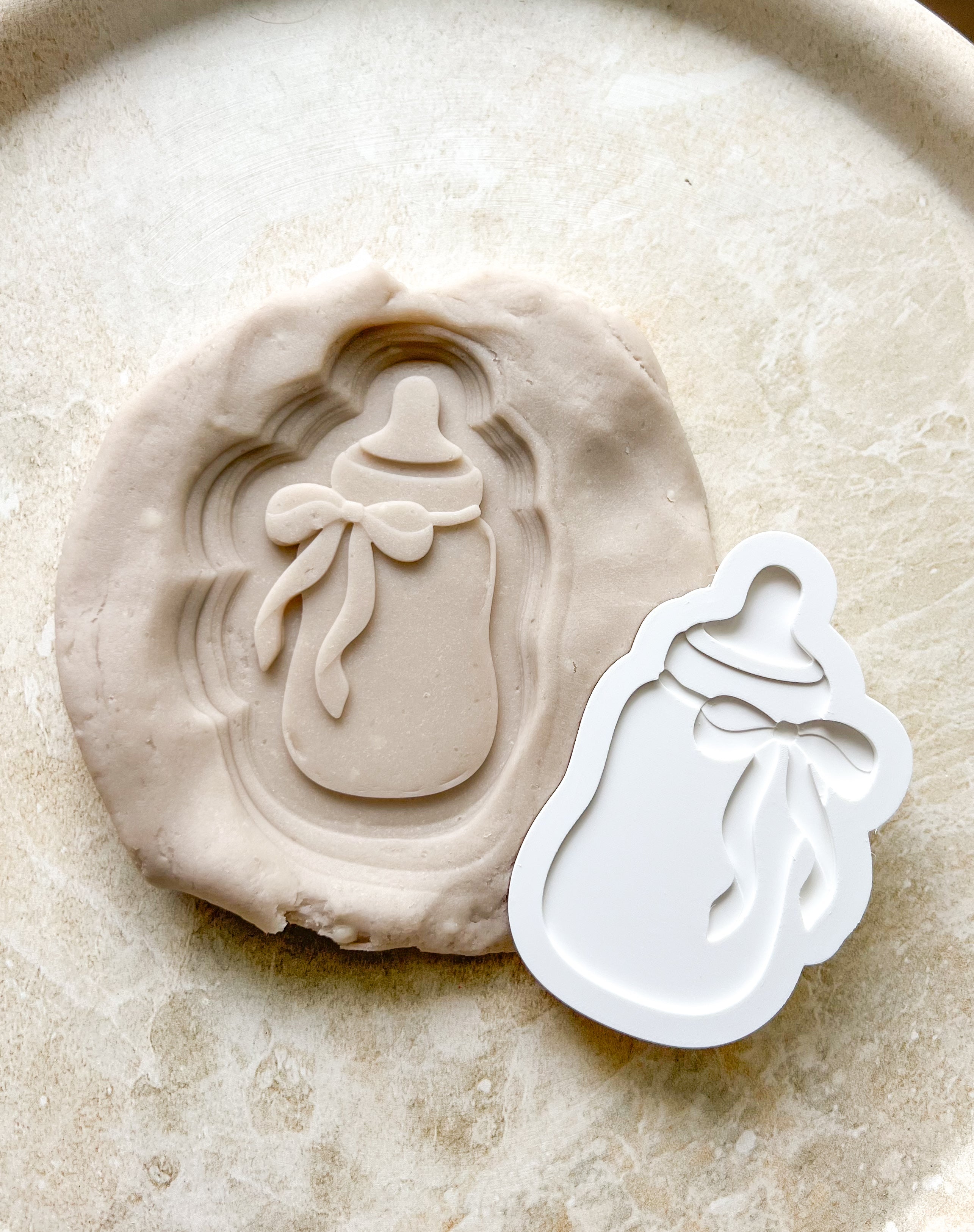 Baby bottle with bow debosser and cutter