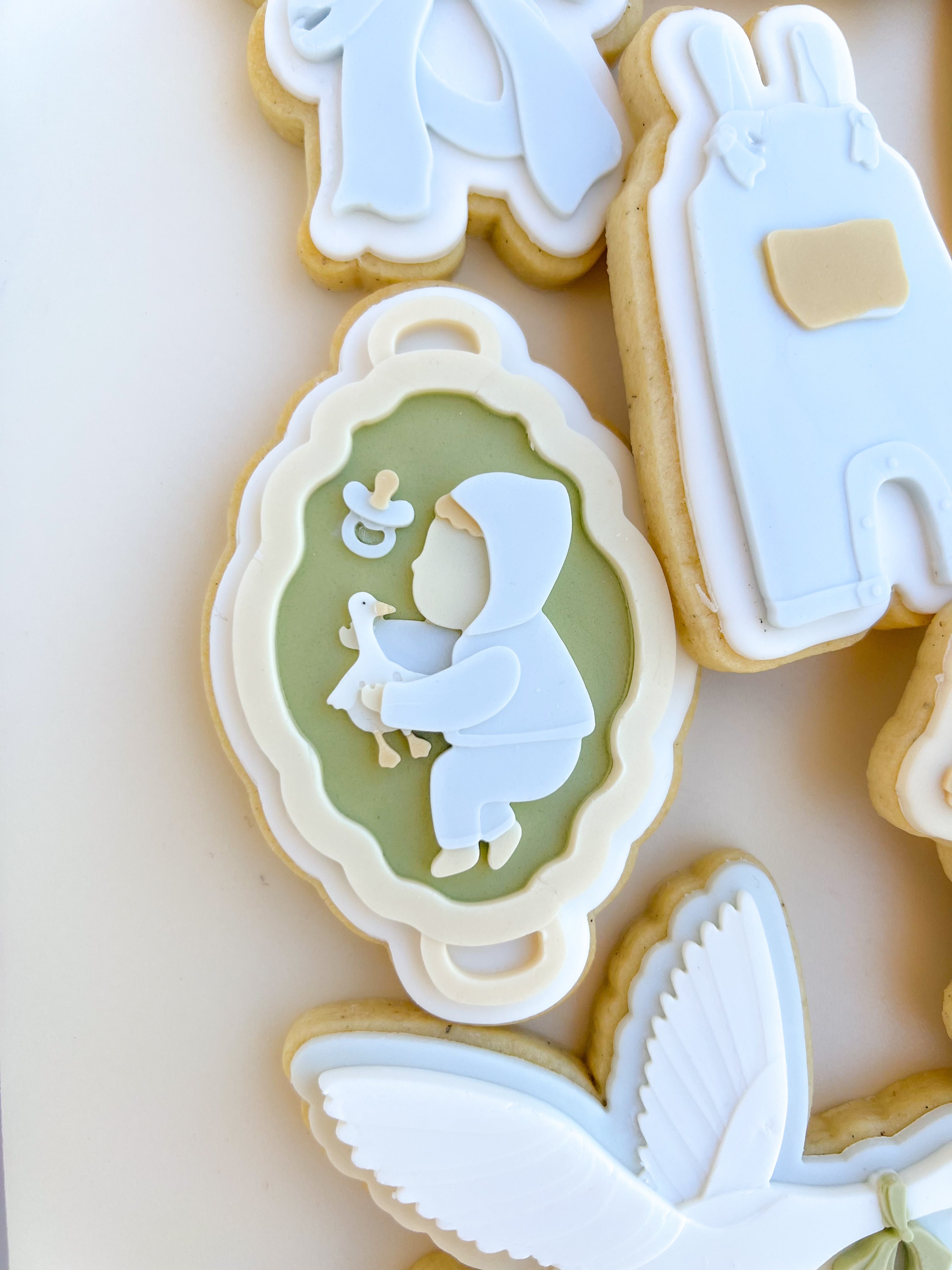 Baby and toy goose on flat bassinet debosser and cutter