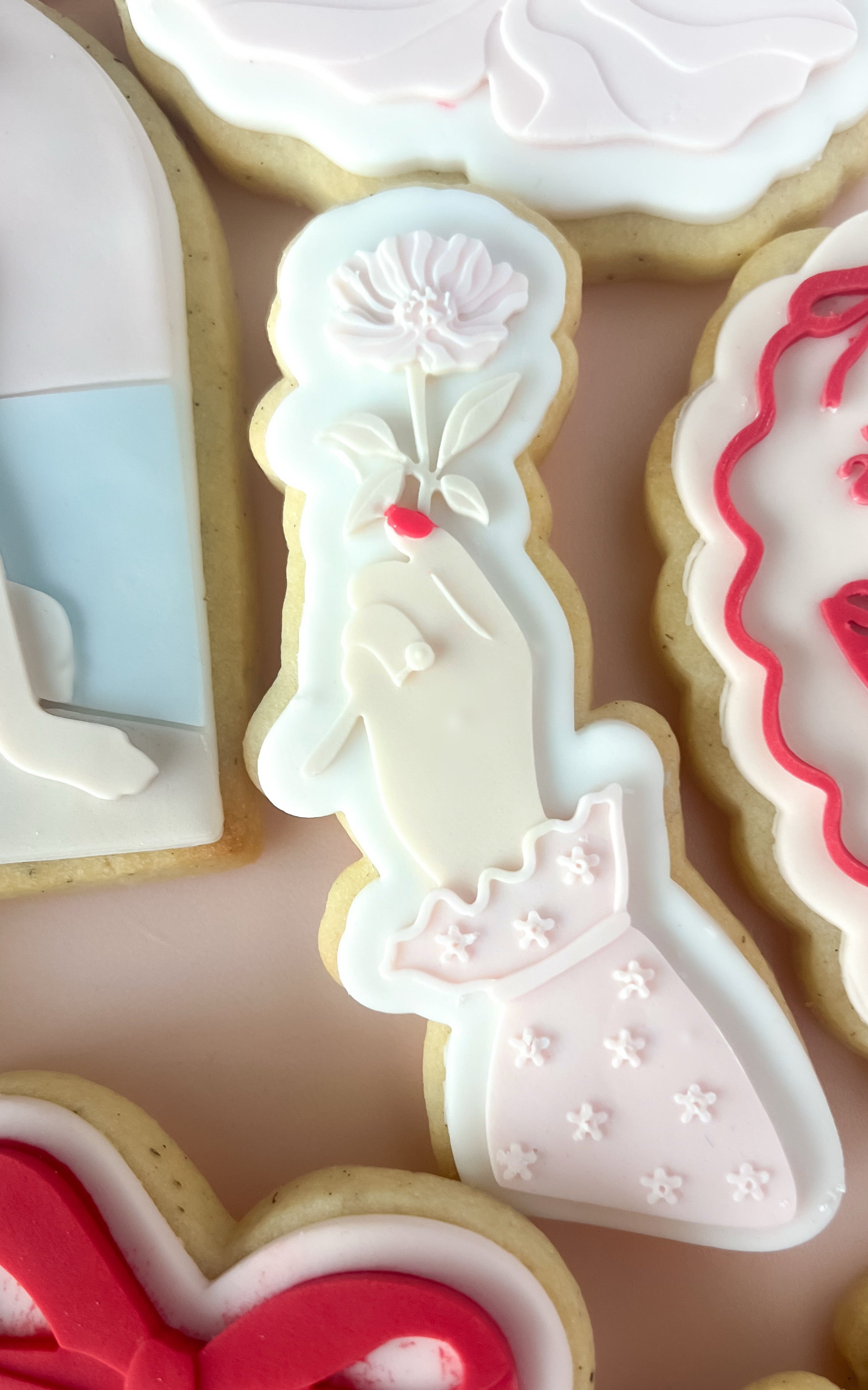 Hand with engagement ring holding frilly flower debosser and cutter