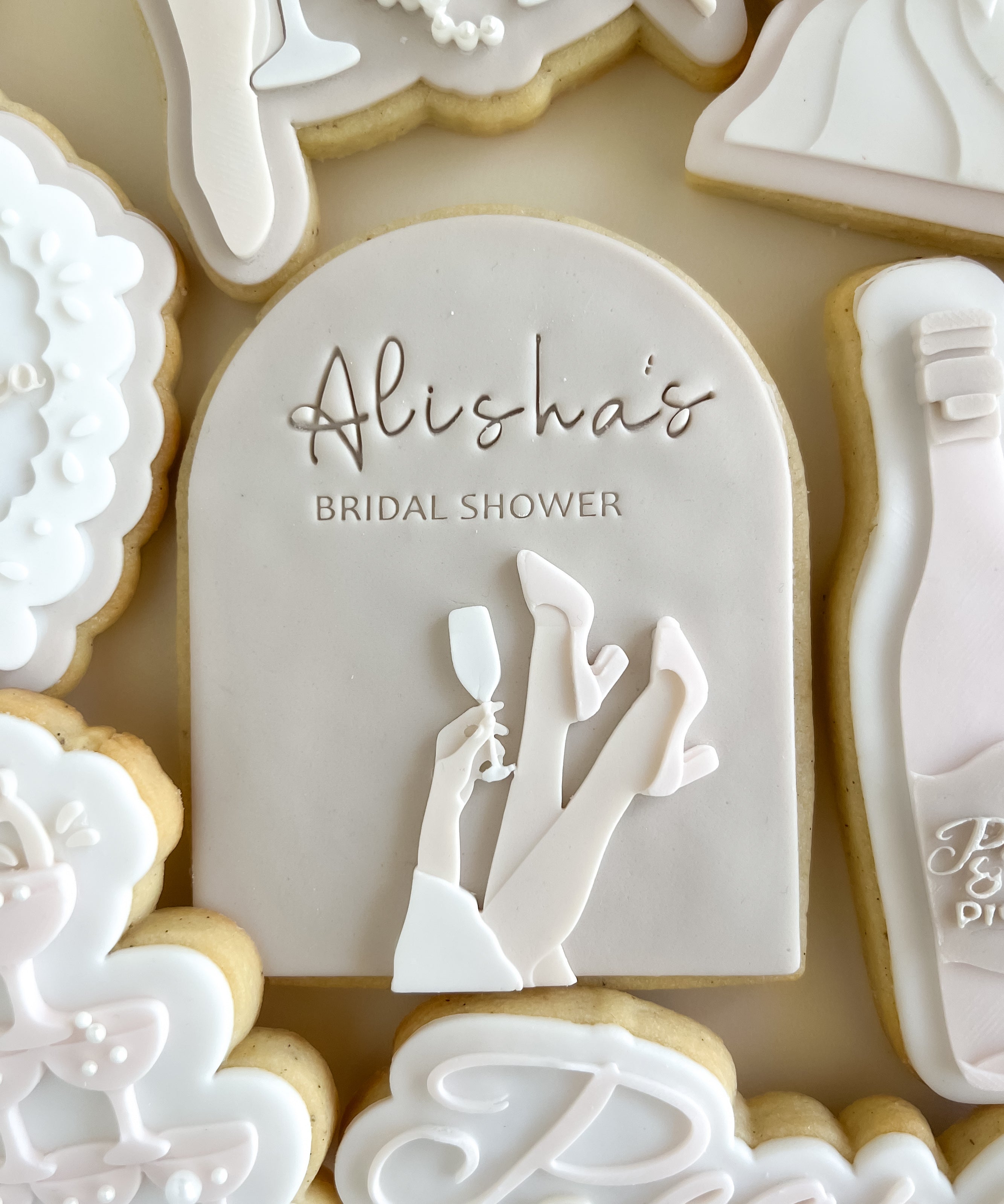 Bridal heels up holding champagne debosser and arch cutter